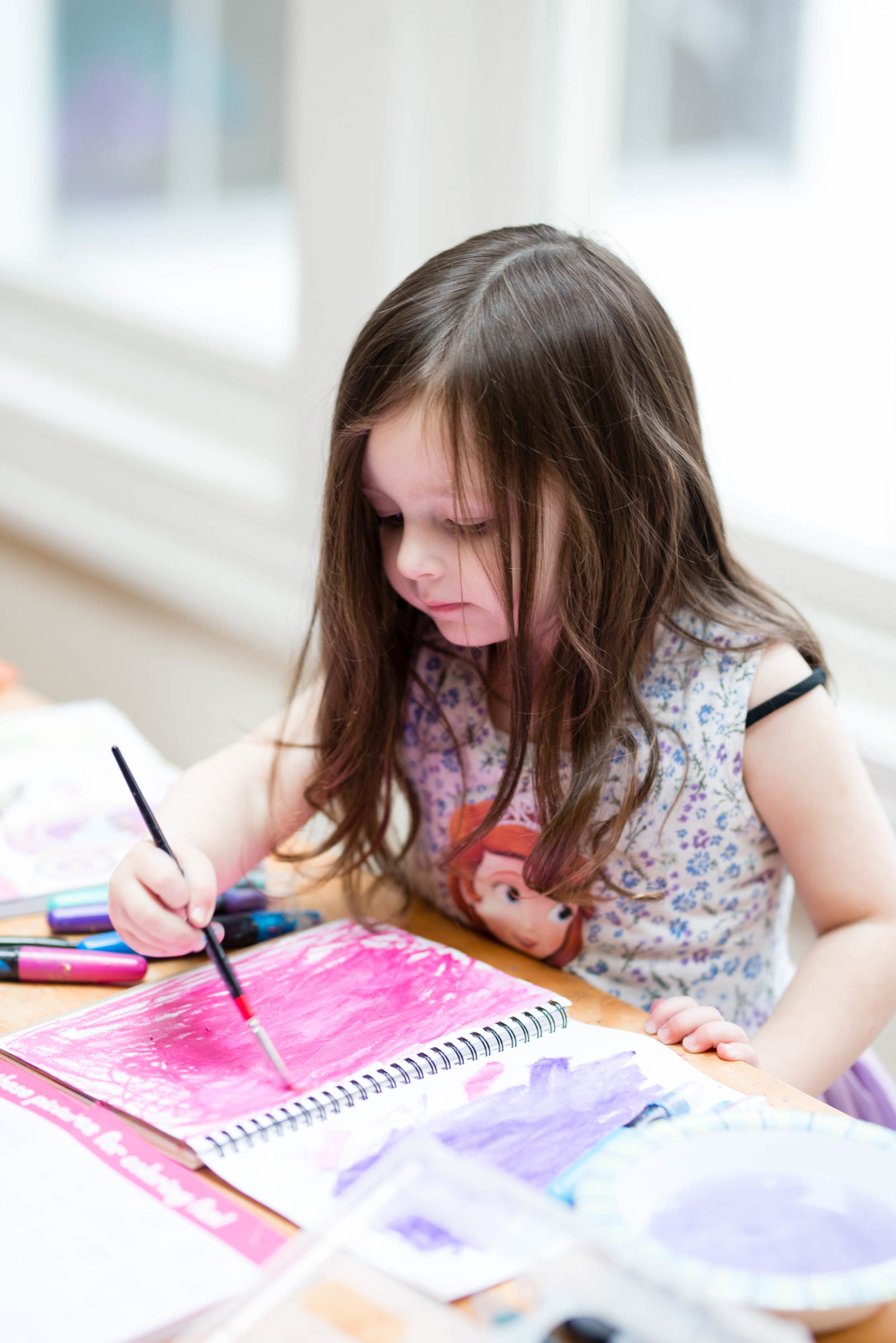 Girl painting with creamy gel stick crayons (one of our favorite art supplies for kids).