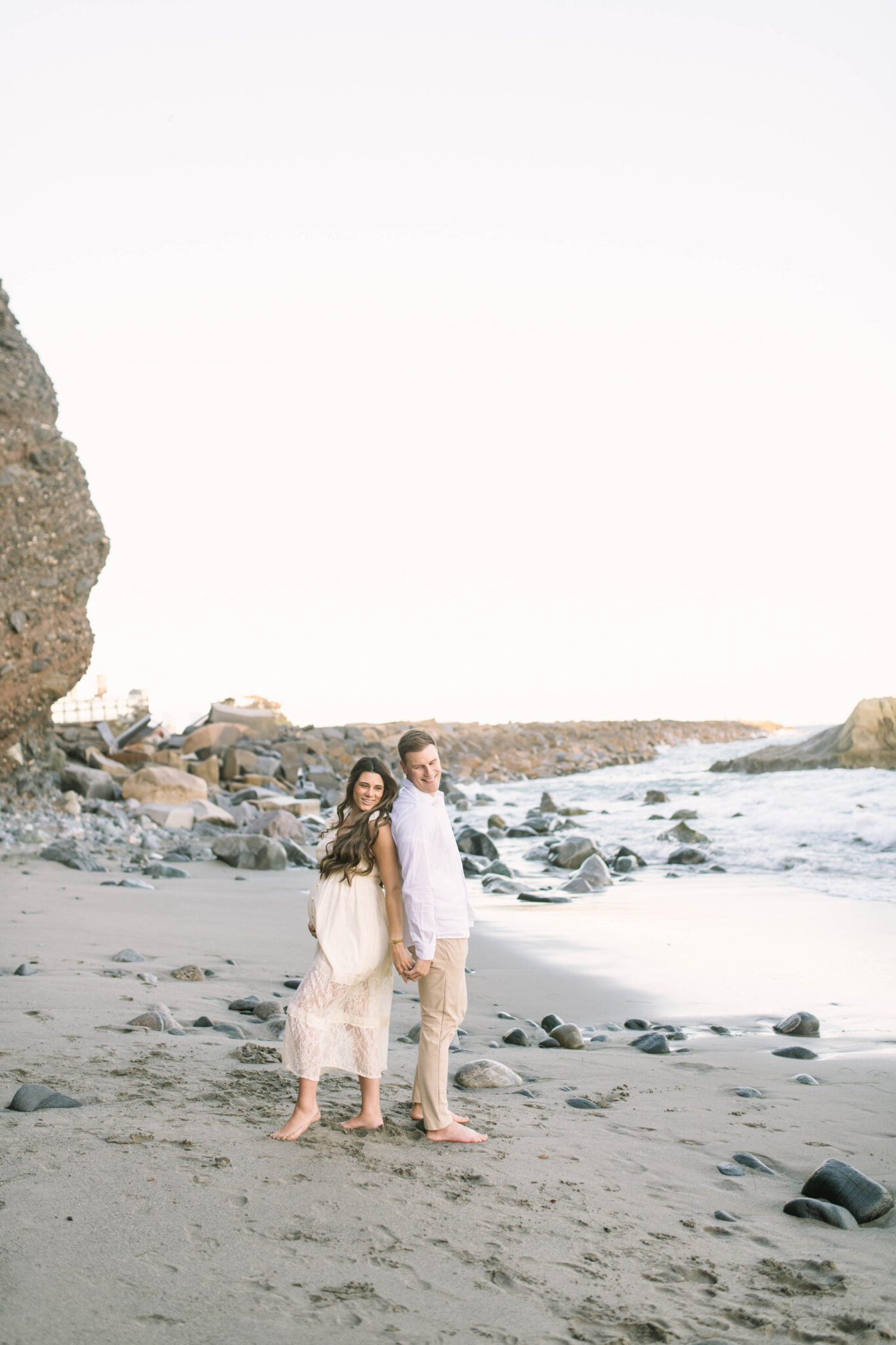 What to wear for maternity photos, mom in a flowy maxi dress on the beach.