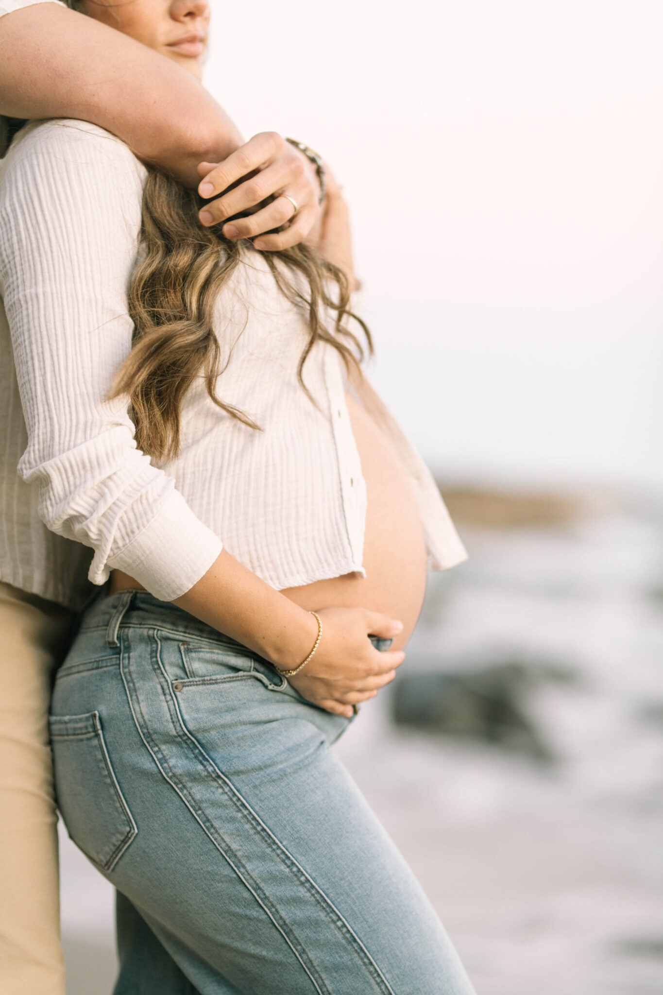 at-home lifestyle maternity shoot. Alt: "At-home maternity photo outfit, jeans and open linen button-up