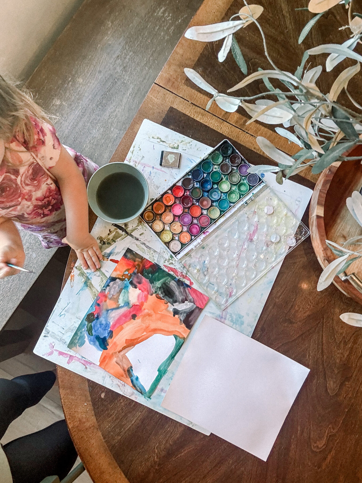 toddler water color painting at table.