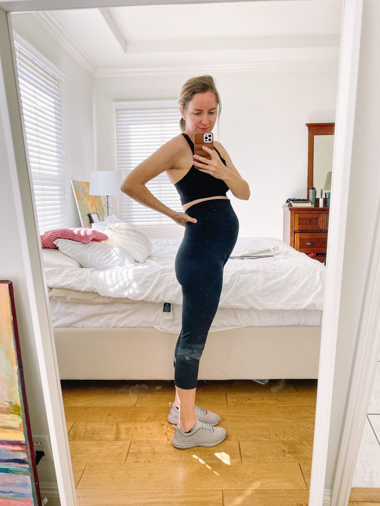 Pregnant mom in black maternity leggings and a black sports bra