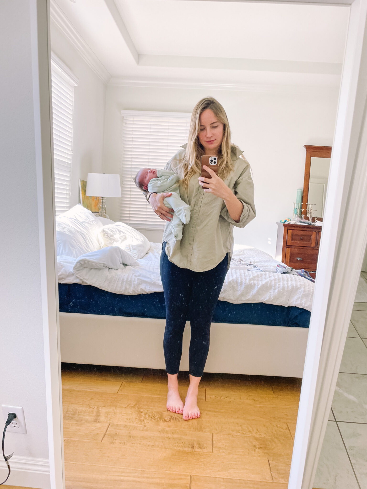 holding a newborn home from the hospital while wearing maternity leggings.
