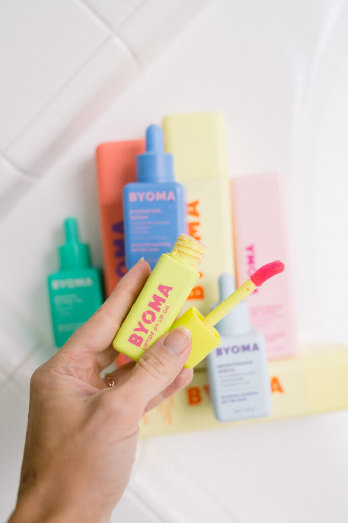 BYOMA lip peptide treatment held in bathroom.