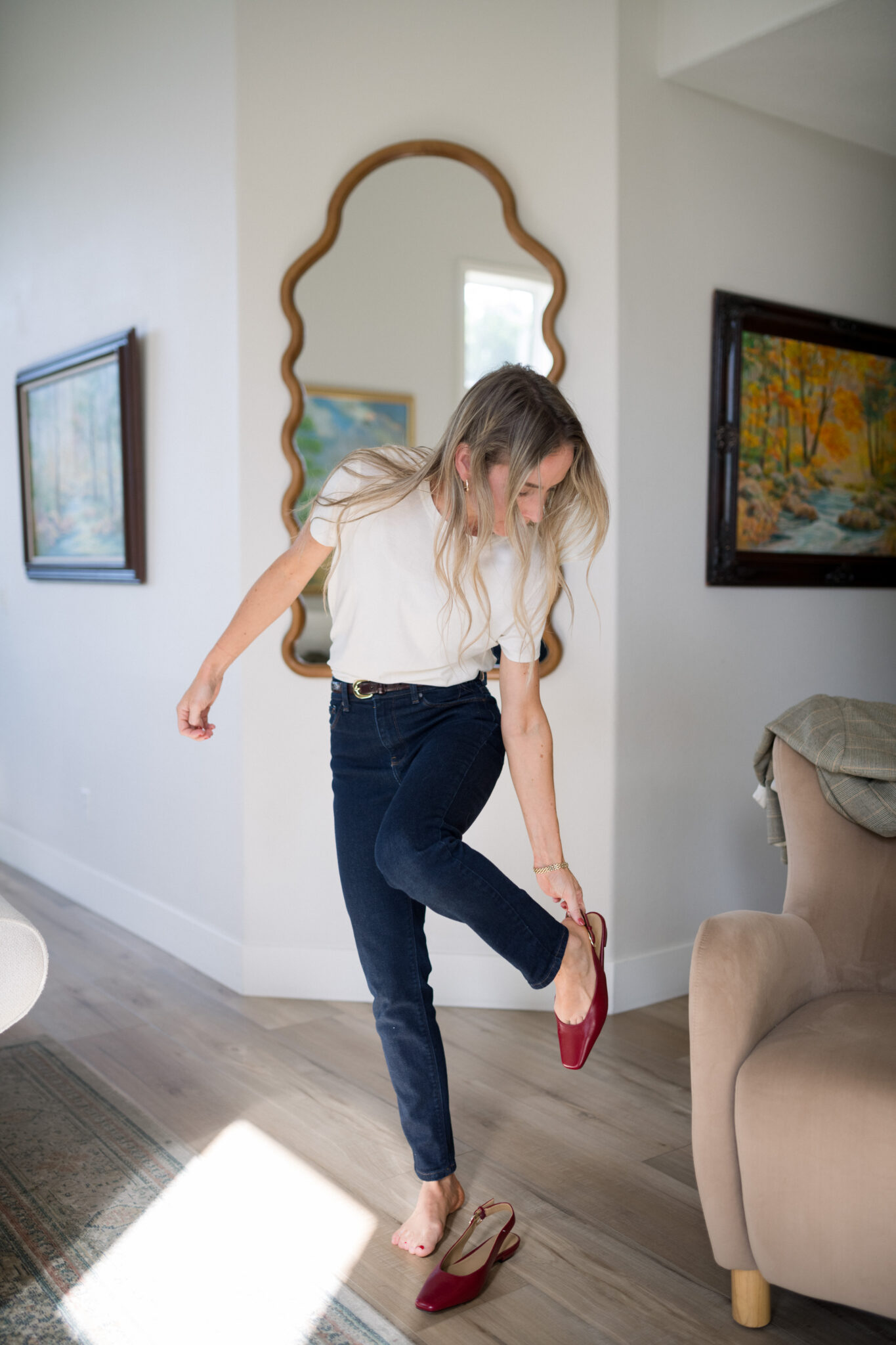 Elisabeth in a white crew tee and Mott & Bow Oliver mom jeans slipping on red slingback flats