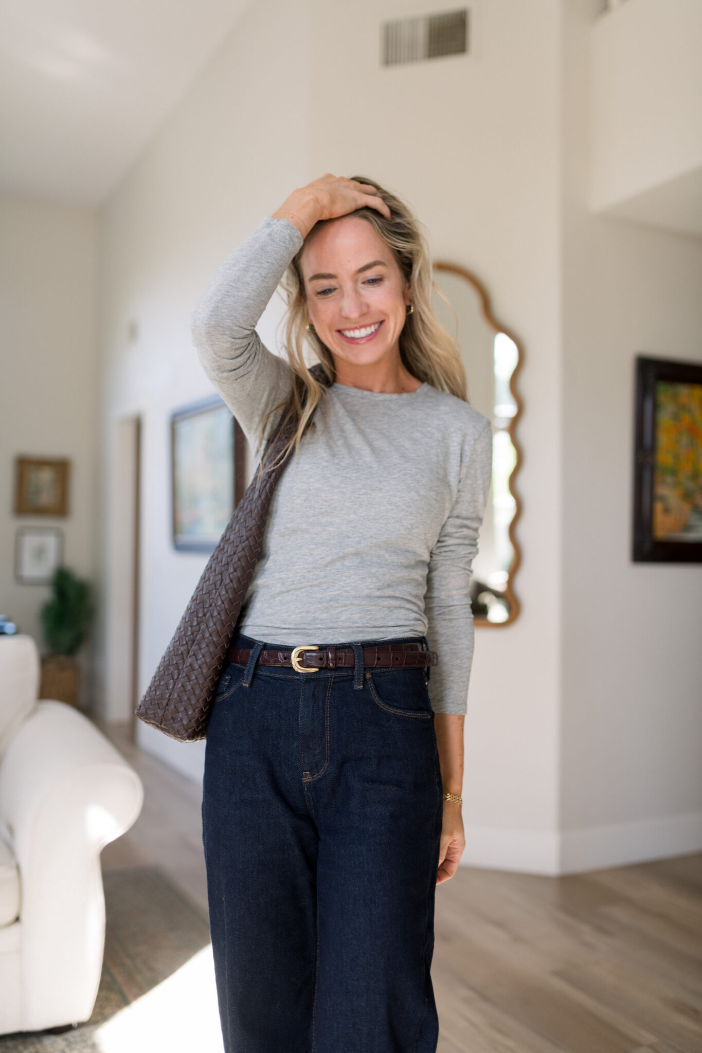 Elisabeth smiling in the Mott & Bow Long Sleeve Crew Tee Marcy in Heather Gray with dark Gilmore wide leg jeans