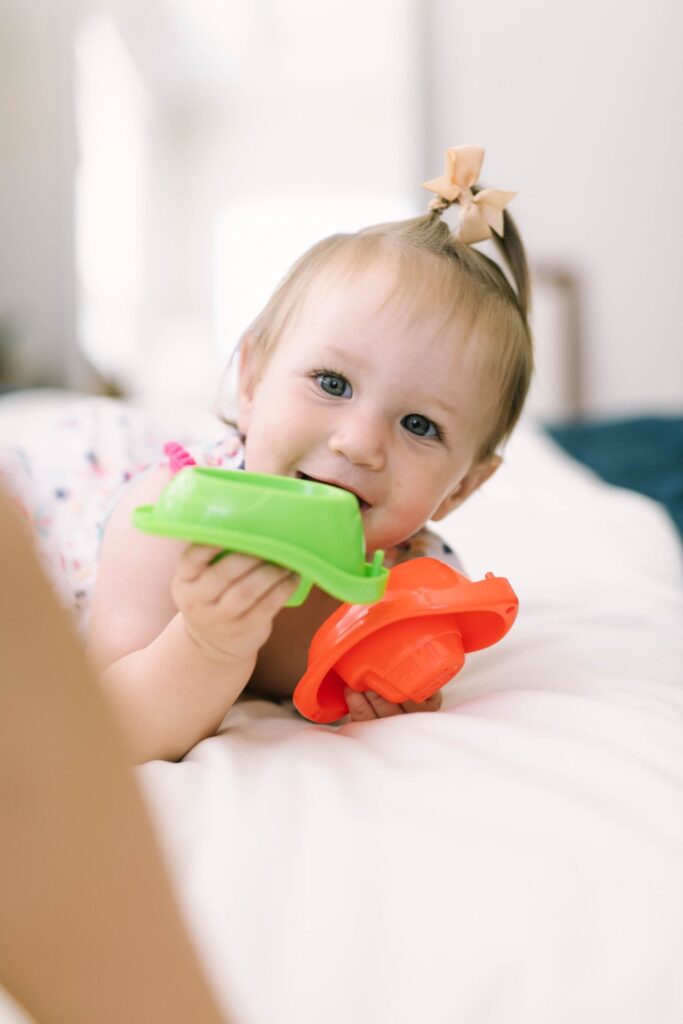 One year old chewing on a toy boat